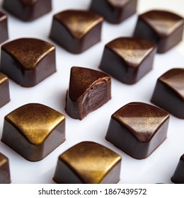 Cut Luxury Chocolate Handmade Candy Bonbons With Ganache Decorated With Golden Edible Glitter On White Background. Exclusive Handcrafted Bonbon 