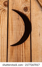 Cut Out Crescent Moon On Wooden Outhouse Door.