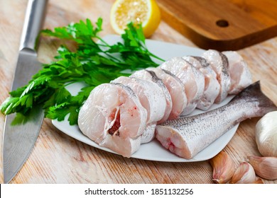 Cut Pieces Of Fresh Hake On Wooden Surface With Seasonings Prepared For Cooking