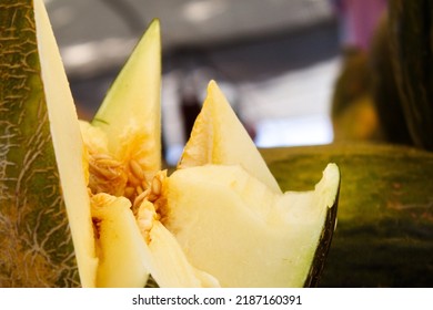 Cut Piel de Sapo melon with the pulp and seeds visible at a weekly market in Murcia