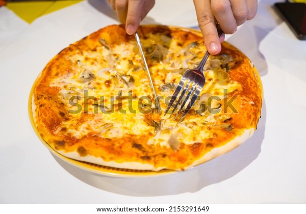 Cut\
the pizza on wooden tray to divided pieces,Pizza is italian food ,\
the kind of food that fits into today\'s life\
style.