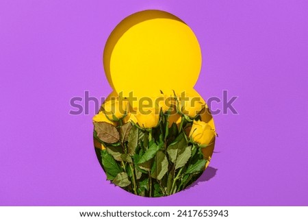 Cut purple paper in shape of figure 8 with beautiful rose flowers on yellow background