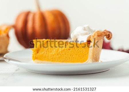 Cut slice of pumpkin pie close up on white background. Autumn orange cake