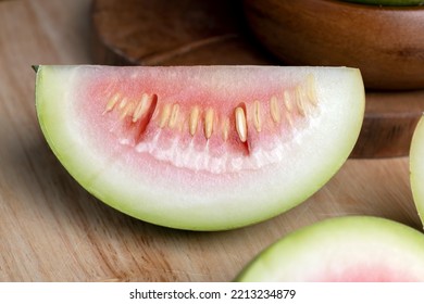 cut small unripe watermelon on a board, cut into pieces unripe watermelon of small size