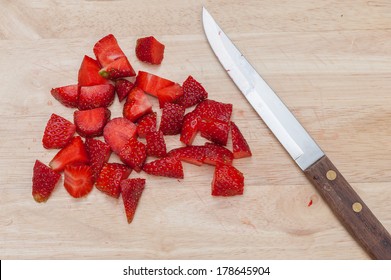 Cut Strawberries On Wood Board With Knife