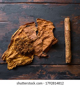 Cut Tobacco And Tobacco Leaves With Cigar On Wood Background On Vintage Dark Table. Overhead Shot Top View