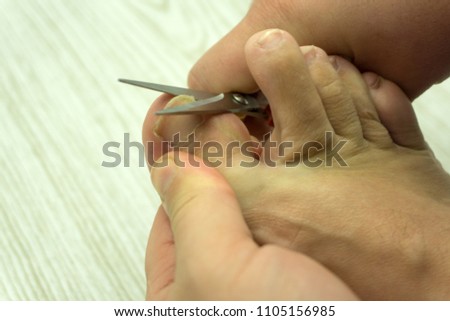 To cut toenails, the scissors in hand