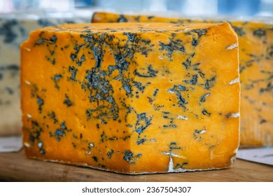 A cut truckle of blue cheese in a cheesemongers, with a shallow depth of field - Powered by Shutterstock