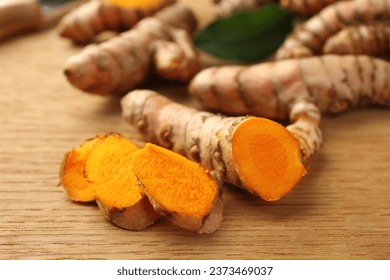 Cut turmeric roots on wooden table, closeup - Powered by Shutterstock