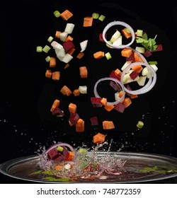 Cut Vegetables Splash In Water Soup Cooking Concept Isolated On Black Background