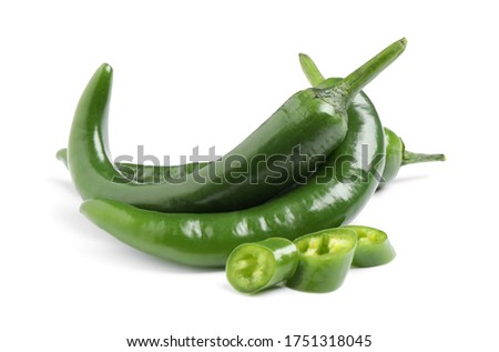 Cut and whole green hot chili peppers on white background
