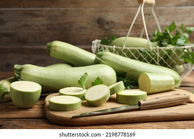 Cut and whole ripe zucchinis on wooden table