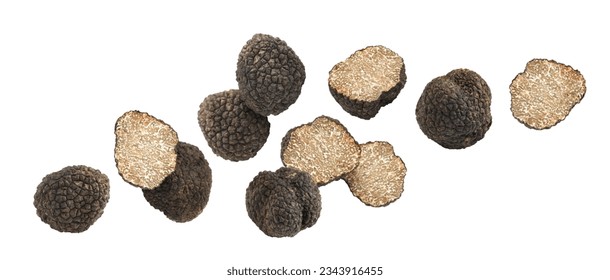 Cut and whole truffles falling on white background