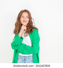 Cut Young Female Girl With Happy Smile, Looking Away, Standing Against White Background In Green Shirt. Portrait Of Fun Teen Student Studio Shot