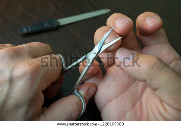 cut your fingernails with small nail\
scissors, nail file on the back blurred\
background