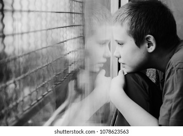 Cute 10 year old autistic boy looking at the rain