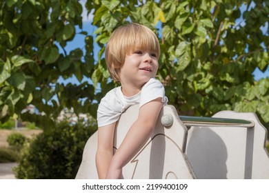 Cute 3 Year Old Kid In A Playground Outdoor.