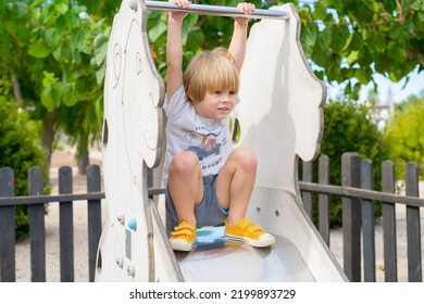 Cute 3 Year Old Kid In A Playground Outdoor.