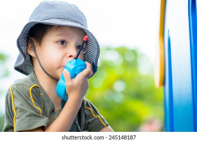 Cute 4 Year Old Mixed Race Asian Caucasian Boy Plays Outside In A Playground With A Toy Walkie Talkie Radio