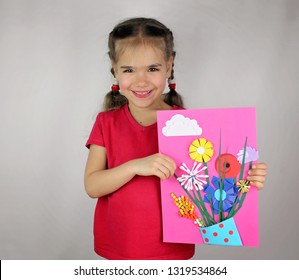 Cute 5  6 years old girl making spring DIY flowers and colored paper for her mom in Mothers Day  decorative punchers to create fun   easy and children  concept for kindergarten  top view image