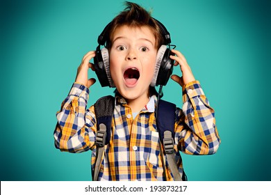 Cute 7 year old boy listening to music on headphones. - Powered by Shutterstock