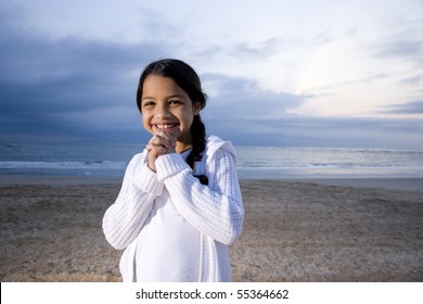 Cute 9 Year Old Hispanic Girl Smiling On Beach At Dawn