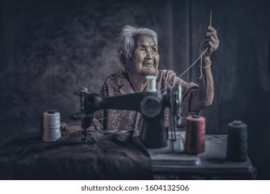 Cute 90 Year Old Senior Woman Using Vintage Sewing Machine. Adorable Elderly Woman Sewing Clothes In Her Old Family Home.