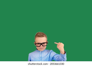 Cute 9s Boy Kid Showing Middle Finger Gesture On The Green Isolated Background.Copy Space.