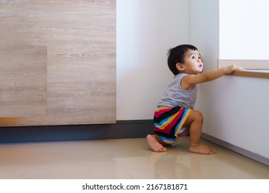 Cute active asian little baby boy is try to stand on the floor and trying begin to walk for first step himself, concept of learning and developing of child in the first year of life.