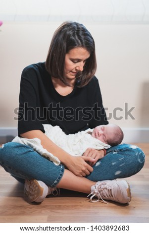 Similar – Mother giving bottle to her newborn