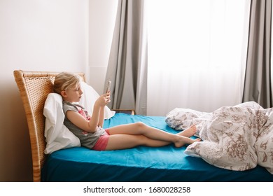 Cute Adorable Caucasian Girl Stay At Home And Call Her Friends On Smartphone. Child Kid Having Face Time Call Talk With People Relatives While On Self Isolation During Quarantine Of COVID-19.