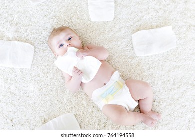 Cute adorable newborn baby of 3 moths with diapers. Hapy tiny little girl or boy looking at the camera. Dry and healthy body and skin for children concept. Baby nursery