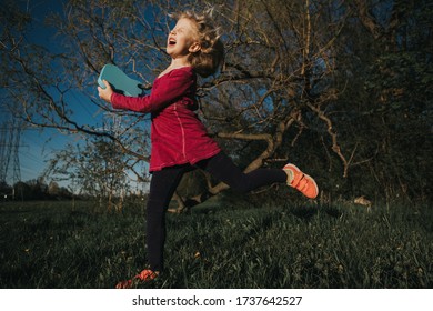 Cute Adorable Young Girl Playing Guitar Toy Outdoor. Girl Pretending To Be A Rock Music Star. Adorable Funny Child Having Fun In Park. Weird Funny Hilarious Authentic Candid Childhood Moments. 