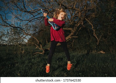 Cute Adorable Young Girl Playing Guitar Toy Outdoor. Girl Pretending To Be A Rock Music Star. Adorable Funny Child Having Fun In Park. Weird Funny Hilarious Authentic Candid Childhood Moments. 