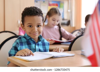 Cute African American Boy Doing Homework In Classroom At School