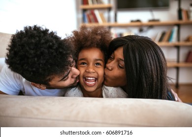 Cute African American Family Sharing A Kiss And Relaxing At Home.