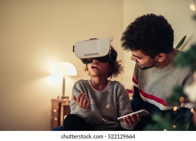 Cute african american girl trying VR glasses at home. - Powered by Shutterstock