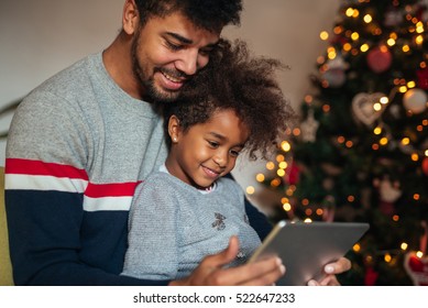 Cute African American Girl Using Tablet With Dad At Home.