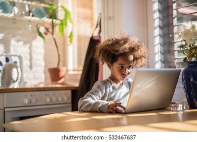 Cute African American Girl Using A Computer At Home.