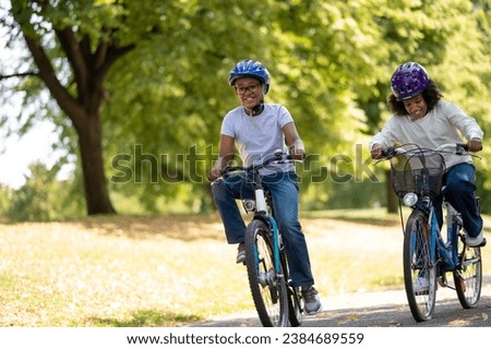 Cute african american kids riding bikes in the park