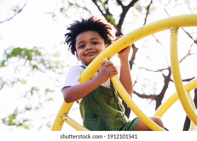 Cute African American little kid boy having fun while playing on the playground in the daytime in summer. Outdoor activity. Playing make believe concept. Outside education - Shutterstock ID 1912101541
