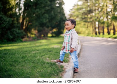 Cute African American Toddler Having Fun Outdoors In Park.