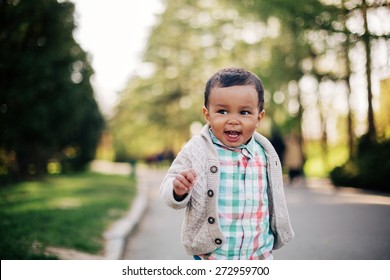 Cute African American Toddler Having Fun Outdoors In Park.