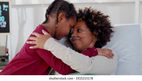 Cute African Daughter Visiting Sick Mother In Hospital And Hugging. Ill Black Young Woman Patient With Nasal Tube Embracing Little Daughter Visitor In Hospital Ward