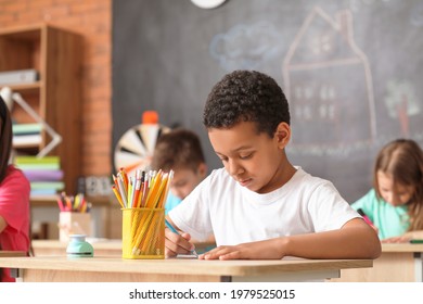 Cute African-American boy drawing at school - Powered by Shutterstock