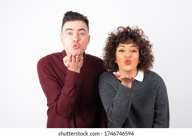 Cute Appealing Couple Blow Kiss At Camera, Demonstrate Love To Boyfriend Or Says Goodbye On Distance, Isolated Over White Studio Background. Attractive Young Woman Shows Sympathy To Someone.