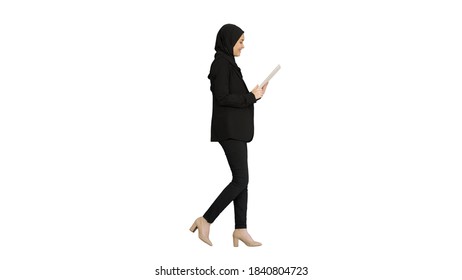 Cute Arabian businesswoman using tablet computer while walking o - Powered by Shutterstock