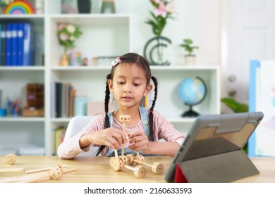 Cute Asian 6 Years Old Asian Little Girl Is Present Her Wooden Robot To Online Classroom, Concept Of Creativity, Learning, Virtual, Connect And Technology, Montessori, Education And Kid Development.
