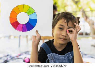 Cute Asian artist girl holding color chart in art school - Powered by Shutterstock