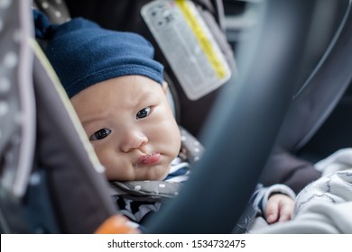 Cute Asian Baby In Child Car Seat Going For A Family Road Trip. Baby Looking At The Camera.